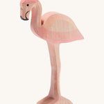 Ostheimer wooden flamingo in pink with black beak on a cream background.