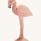 Ostheimer wooden flamingo in pink with black beak on a cream background.