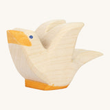 A white wooden Ostheimer flying pigeon figure on a cream background.