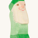 A green wooden Ostheimer dwarf figure on a cream background.