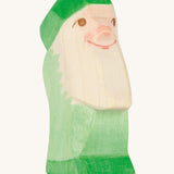 A green wooden Ostheimer dwarf figure on a cream background.