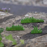 The Ostheimer Wooden green Figures set placed on a stone wall outdoors.