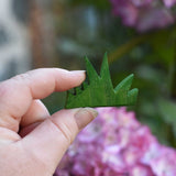 The smallet piece from the Ostheimer Wooden green grass Figures set shown in hand for scale.