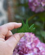 The smallet piece from the Ostheimer Wooden green grass Figures set shown in hand for scale.