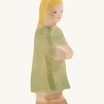 A wooden Ostheimer wooden Gretel with blonde hair figure wearing a green dress on a cream background.