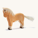 A brown wooden haflinger Ostheimer horse figure on a cream background.