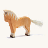 A brown wooden haflinger Ostheimer horse figure on a cream background.