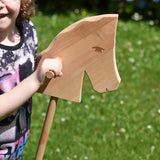 Close up of the Ostheimer Hobby Horse's head, a child is holding the horse by it's handles.