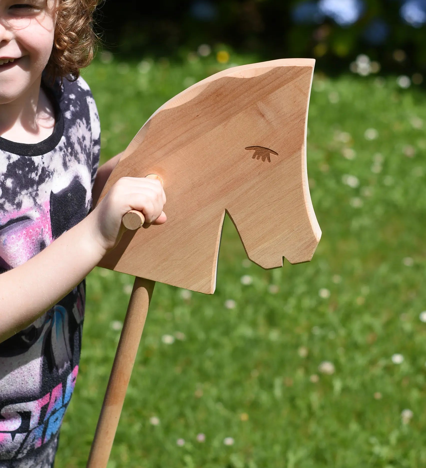 Close up of the Ostheimer Hobby Horse's head, a child is holding the horse by it's handles.