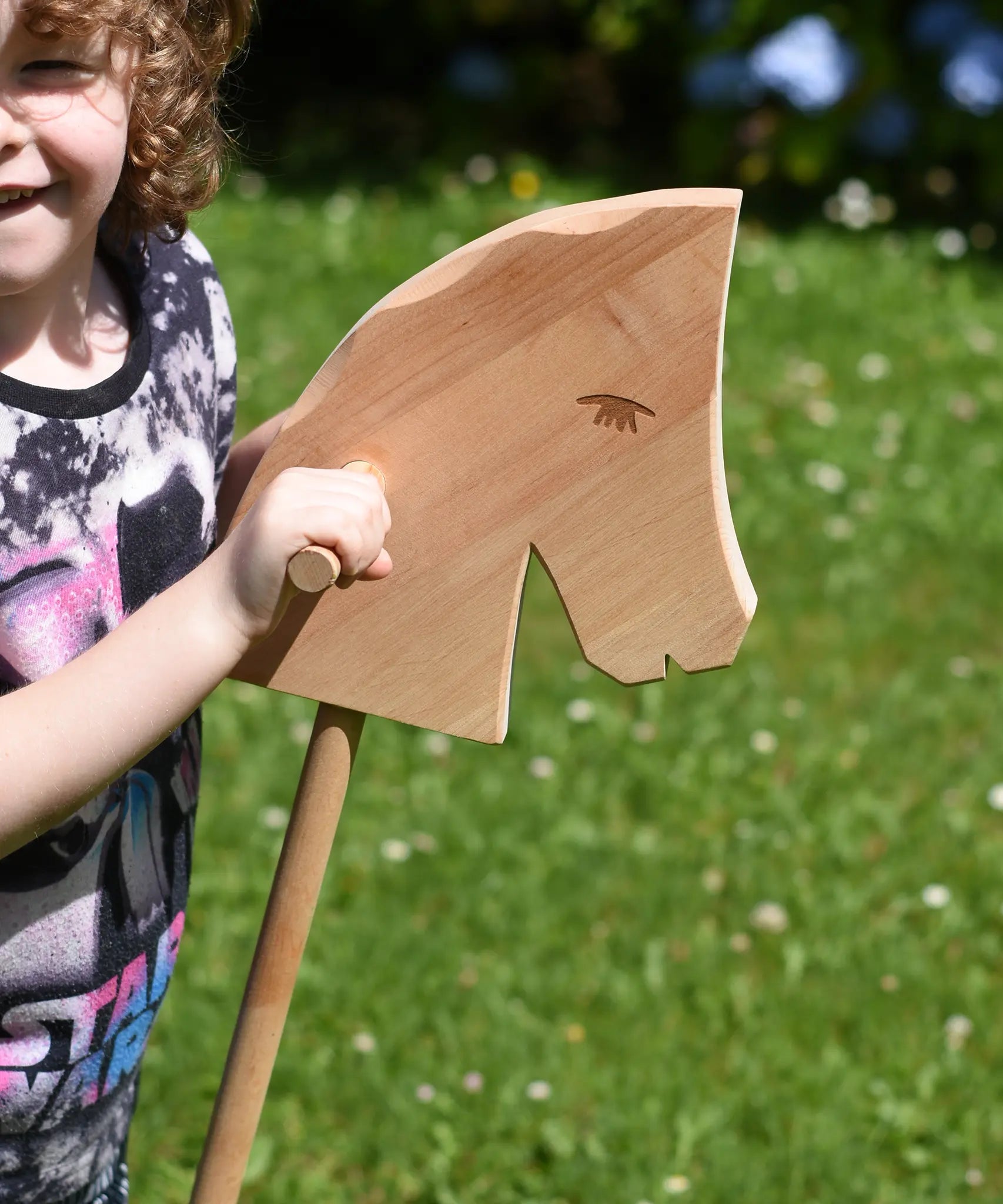 Close up of the Ostheimer Hobby Horse's head, a child is holding the horse by it's handles.