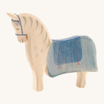 Ostheimer Wooden Horse Figure with a blue painted saddle, on a cream background