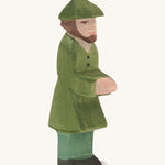 A wooden Ostheimer huntsman figure wearing a green coat and a green hat on a cream background.