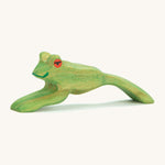 A green wooden Ostheimer jumping frog figure on a cream background.