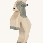 A grey and white wooden Ostheimer jumping goat figure on a cream background.
