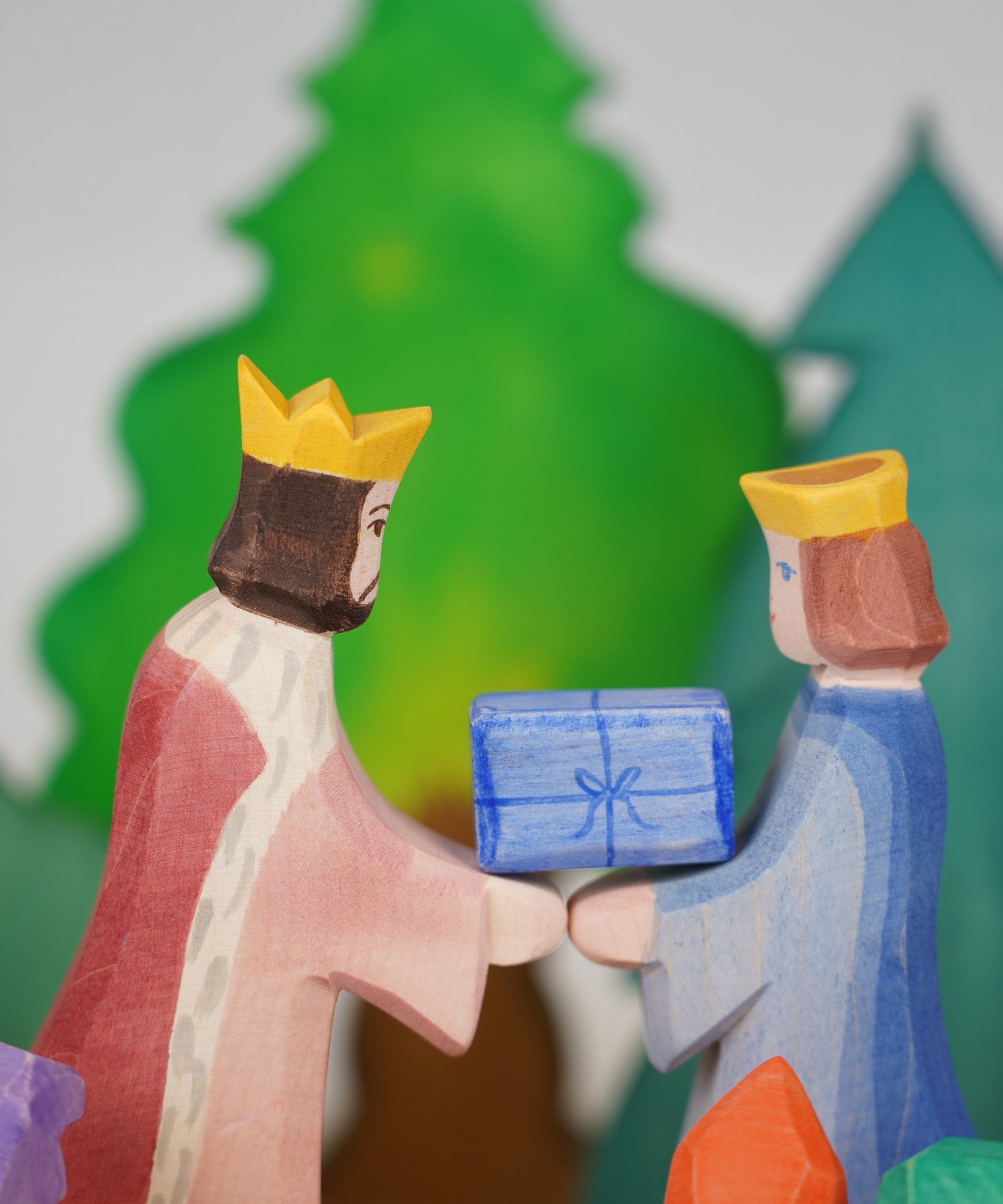 Ostheimer King and Qieen wooden toy figures, handmade in Germany, exchanging a small blue gift, Waldorf and small world play scene, sold at Babipur