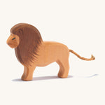 A wooden Ostheimer lion figure on a cream background.