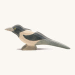 A wooden Ostheimer magpie figure on a cream background.