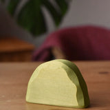Ostheimer middle green bush toy scenery piece placed on a wooden surface.