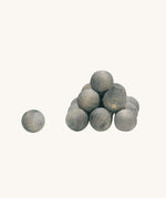Ostheimer kids wooden cannonball toys stacked in a pile on a beige background