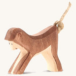 A wooden Ostheimer monkey figure on a cream background.