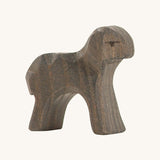 A black wooden moorland lamb on a cream background.