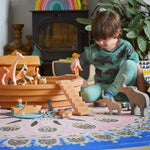 A child playing with the Ostheimer wooden Noah’s Ark with hand-painted animals and figures. Made in Germany this is ideal for small world storytelling and open-ended play, sold at Babipur