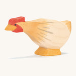 A ochre wooden Ostheimer hen figure with a long neck on a cream background.
