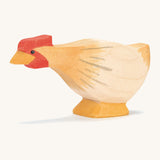 A ochre wooden Ostheimer hen figure with a long neck on a cream background.