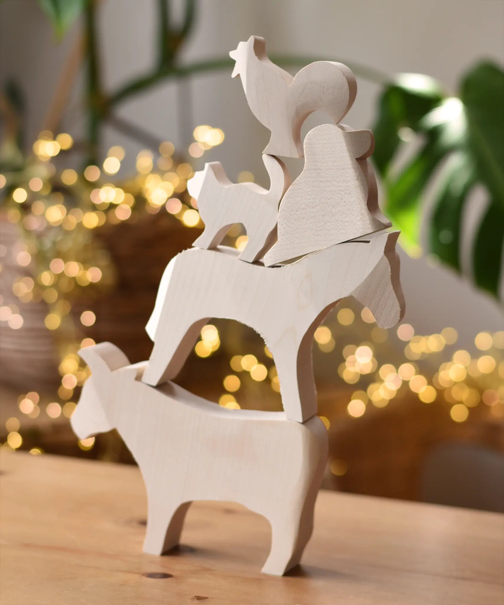 Five Ostheimer paint your own wooden figures stacked on top of each other, cow, horse, dog, standing cat and cockerel.