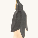 A front wooden Ostheimer penguin figure on a cream background.