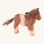 A white and brown wooden Ostheimer pony figure on a cream background.