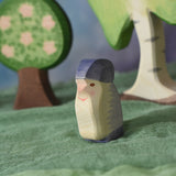 An Ostheimer purple dwarf wooden toy figure placed in a small world play scene. The dwarf figure has a purple coloured outfit with matching hat and a long white beard. The figure has been placed on a green coloured Ostheimer play scarf. These wooden figures are part of a large range of expertly hand crafted, Waldorf inspired, wooden toys here at Babipur. 