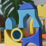 Yellow and blue Ostheimer Rainbow Castle Blocks stacked and balanced on each other.