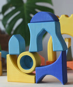 Yellow and blue Ostheimer Rainbow Castle Blocks stacked and balanced on each other.