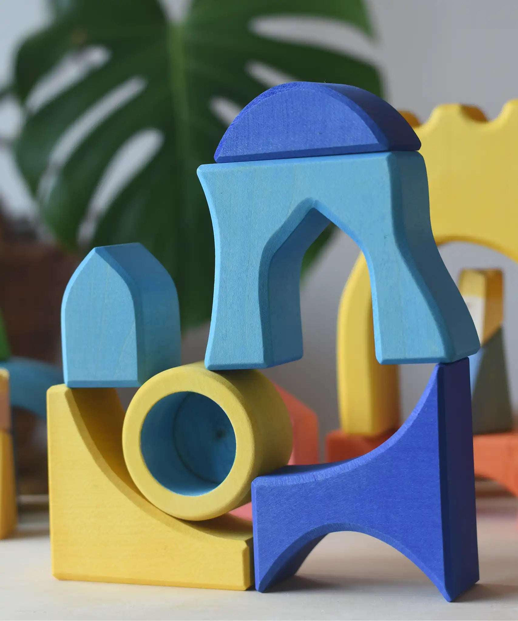 Yellow and blue Ostheimer Rainbow Castle Blocks stacked and balanced on each other.