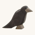 A wooden Ostheimer raven figure on a cream background