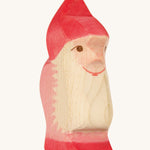 A red wooden Ostheimer dwarf figure on a cream background.