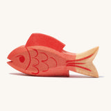 A wooden ostheimer red fish figure on a cream background.