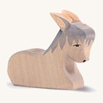 A grey wooden sitting Ostheimer donkey figure on a cream background.