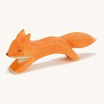A wooden Ostheimer running fox figure on a cream background.