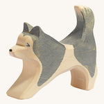 A grey and natural wooden Ostheimer running sled dog figure on a cream background.