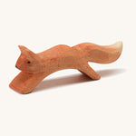 A wooden Ostheimer running squirrel figure on a cream background.
