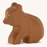 A Ostheimer wooden small brown sitting bear on a cream background.