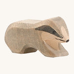 A small wooden Ostheimer badger figure on a cream background.