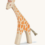 A wooden small Ostheimer giraffe with. head low on a cream background