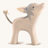 A small grey wooden Ostheimer donkey with its head held high on a cream background.