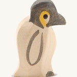 A small wooden Ostheimer penguin figure on a cream background.