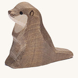 A small wooden Ostheimer sea otter figure on a cream background.
