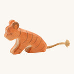 A small sitting Ostheimer tiger figure on a cream background.