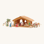 A small wooden Ostheimer stable with the Ostheimer nativity figures around it on a cream background.